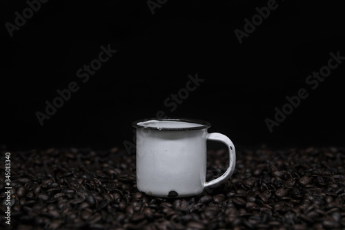 Mug with coffee over coffee beans