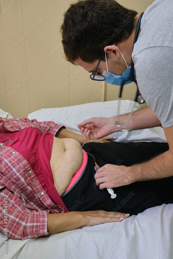 Fototapeta premium a physician doing a subcutaneous vial for the treatment of an adult woman with covid-19 during the pandemic