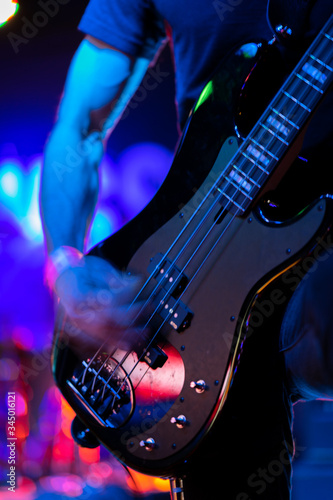 A closeup of a guitarist strumming an electric guitar on stage during a rock music performance at a venue on 6th Street in Austin, Texas. 