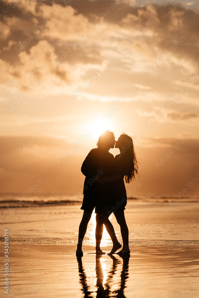 Attractive man and woman enjoying romantic evening on sunset