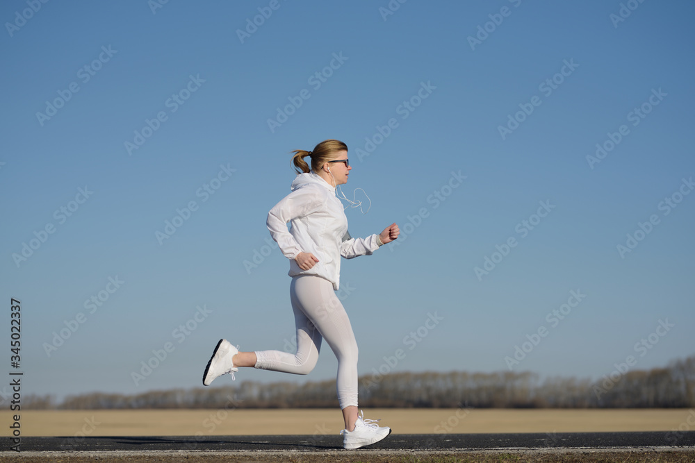Shot of a beautiful adult woman running at sunrise. Shot of a beautiful adult woman running at sunrise.