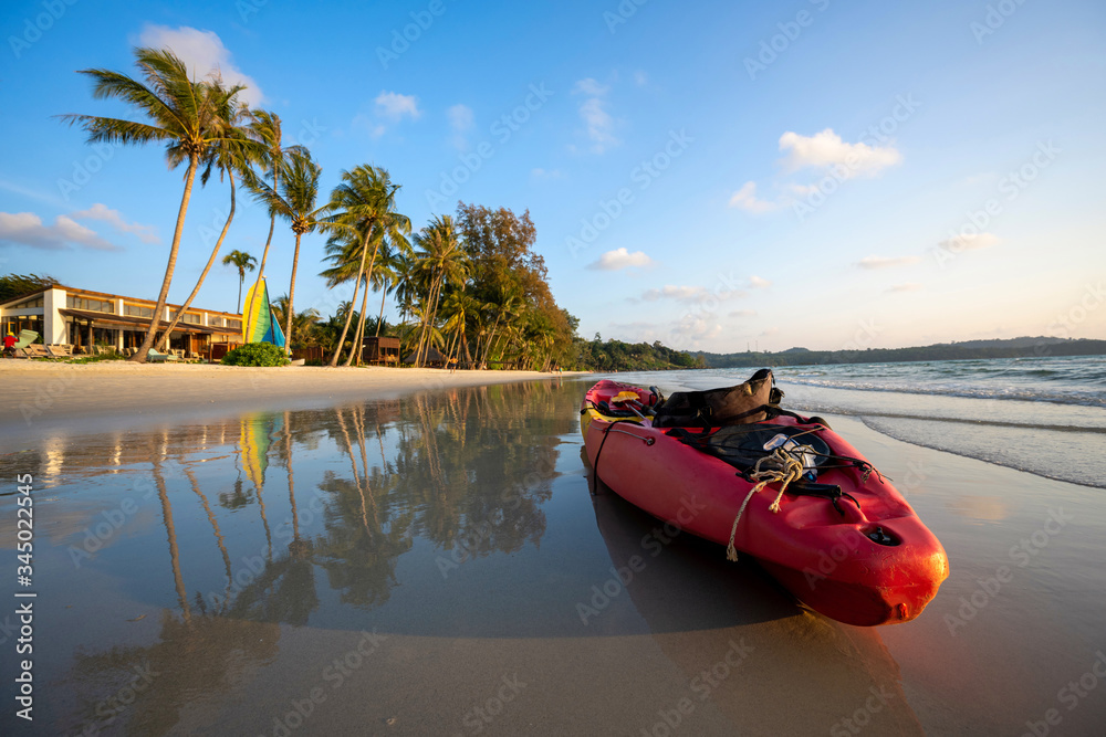 Fototapeta premium Red kayaks are at the beach by the sea in the evening at Ko Kood, Thailand, in the summer holiday concept.