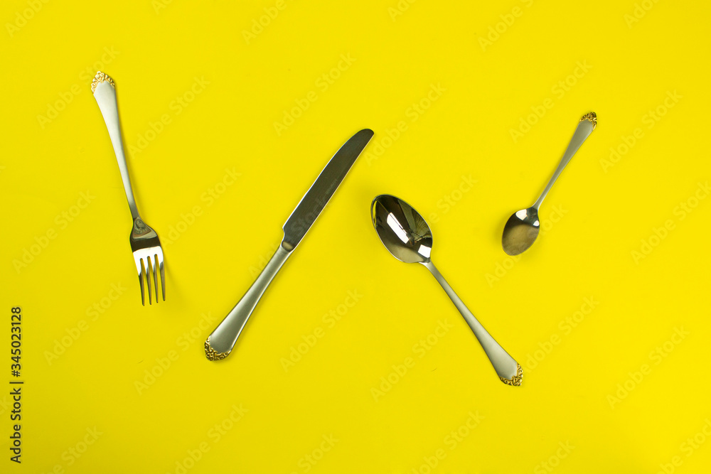 set of cutlery on a yellow background. tableware. silverware and stainless steel. The concept of food, lunch, breakfast and dinner. fork, knife, spoon. set of cutlery on a yellow background. tableware. silverware and stainless steel. The concept of food, lunch, breakfast and dinner. fork, knife, spoon.