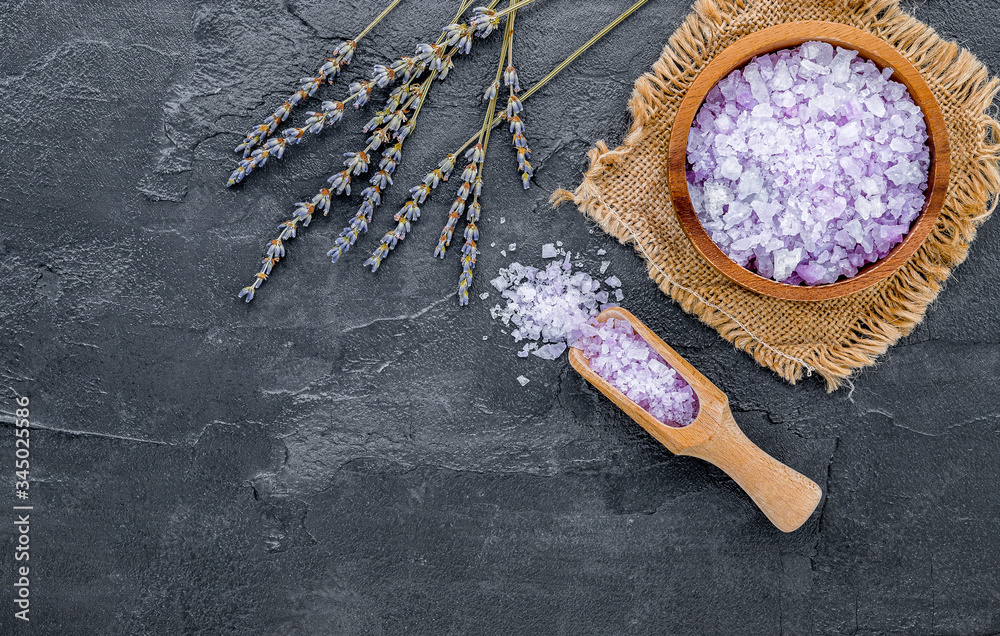 Aromatic purple bath salt with lavender flower on dark concrete