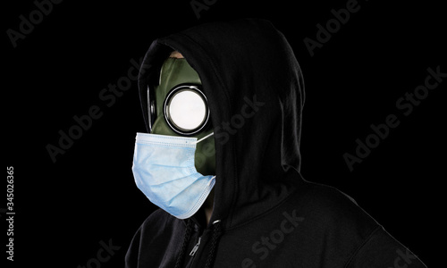 Person wearing old retro hazmat style gas mask and medical mask