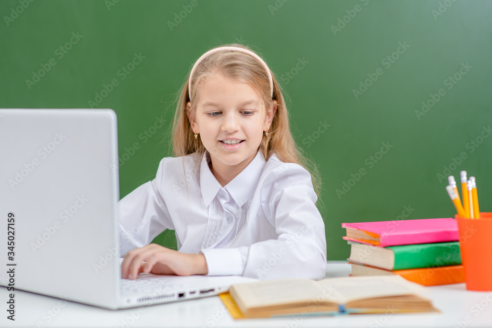 Happy young girl studies with laptop in a school Happy young girl studies with laptop in a school