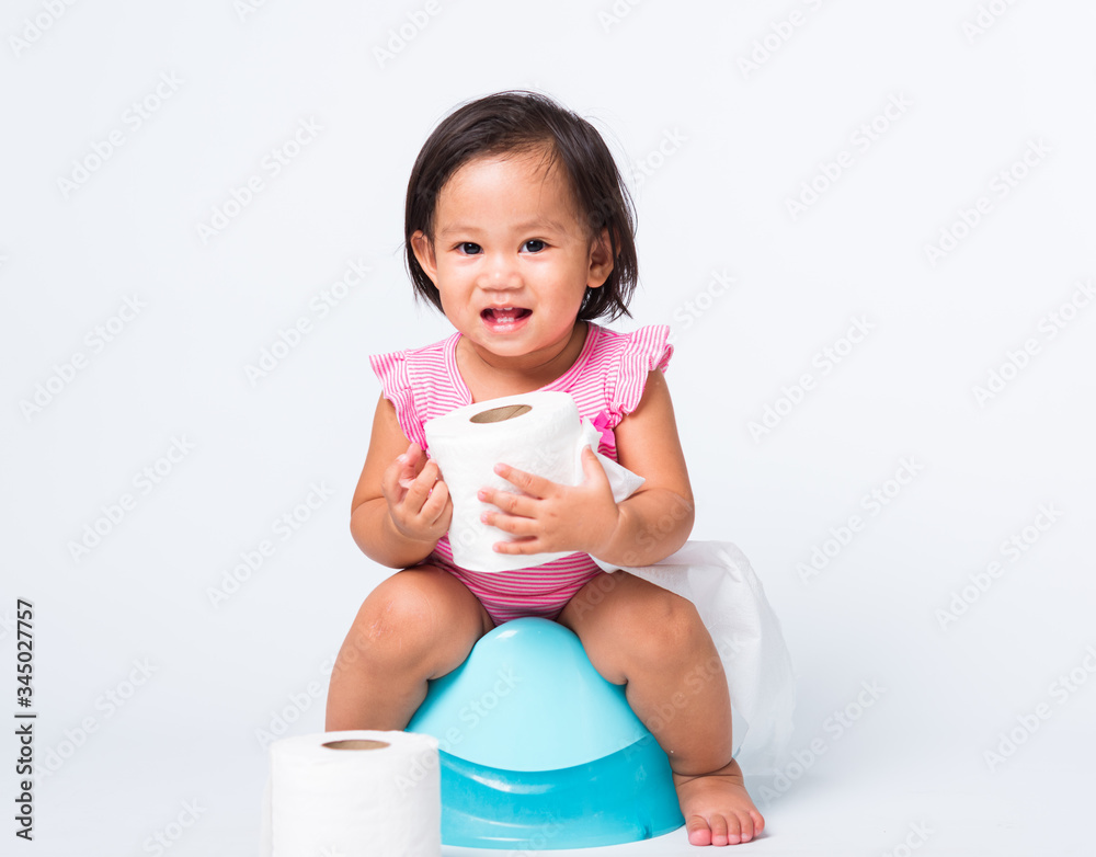 Little girl sitting on toilet training potty on white