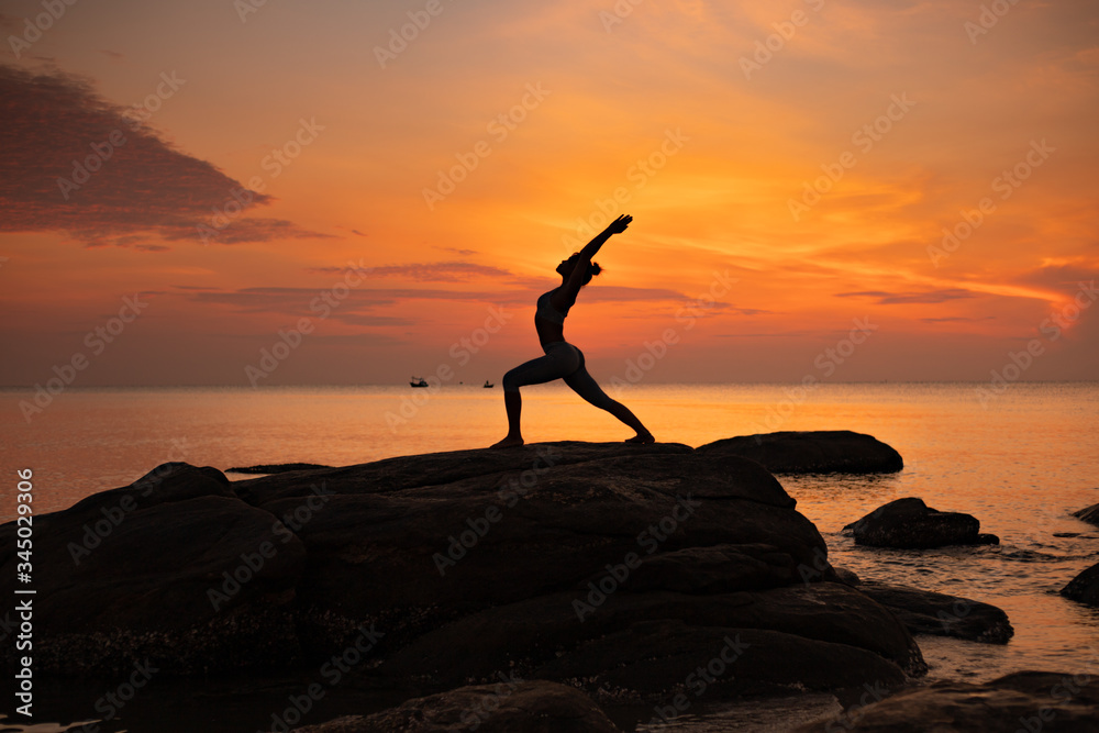 Asian girl practice Yoga on the beach Sunrise morning day