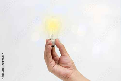 Hand holding Lamp lighting with bokeh background for idea concept business,environment concept
