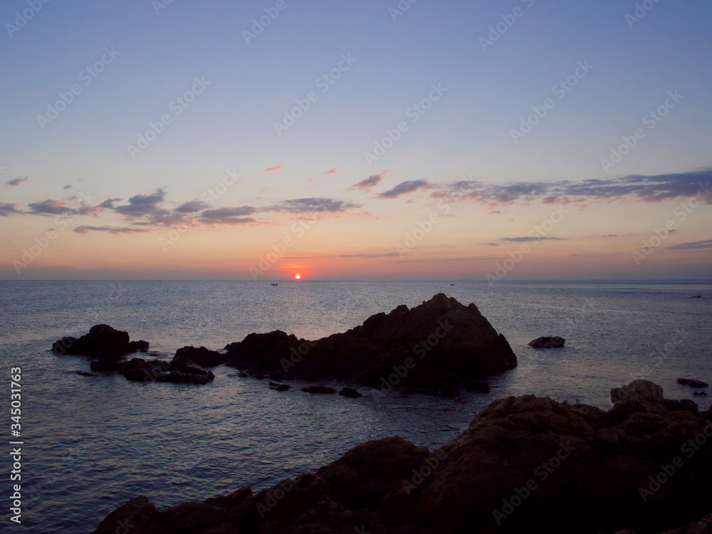 Sunset sky  and calm sea ocean  with silhouette rock beach