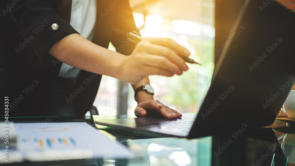 Closeup image of businesswoman pointing finger at laptop computer while working in office