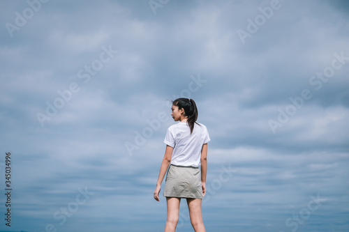 Happy young woman on sky background.