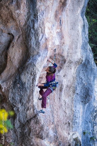 A strong woman climbs a rock, Rock climbing in Turkey.