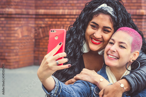 Happy brazilian bright girls take a selfie. Girlfriends have fun outdoors. Friends photographed. Youth lifestyle photo