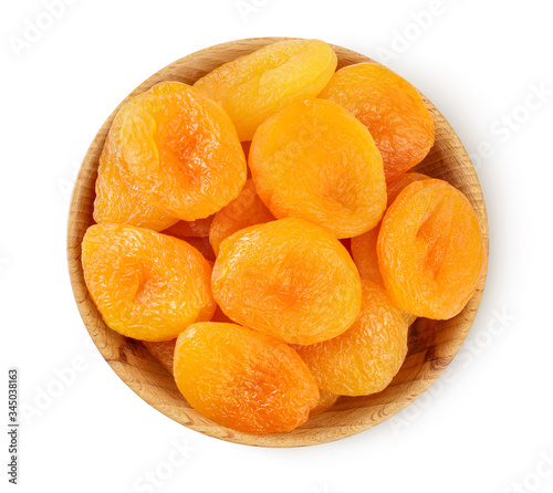 Dried apricots in wooden bowl isolated on white background with clipping path and full depth of field. Top view. Flat lay