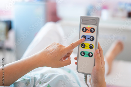 hospital bed remote control controlling adjusting head position of bed for patients comfortability, medical care and healthcare concept accessories and equipment in hospital bed in background