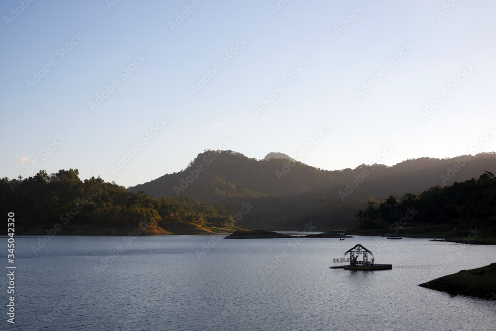 beautiful lake and mountains with floating house , located in waduk sermo beautiful lake and mountains with floating house , located in waduk sermo