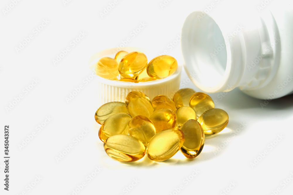 golden fish oil capsules in glass bowl on white background, panoramic shot golden fish oil capsules in glass bowl on white background, panoramic shot