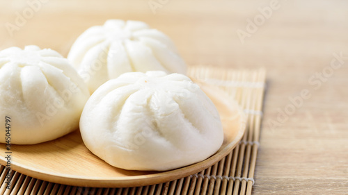 Steamed buns stuffed with minced pork on wooden plate, Asian food