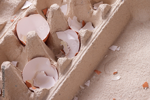 Fotografie Broken yellow egg shells in a cardboard egg box