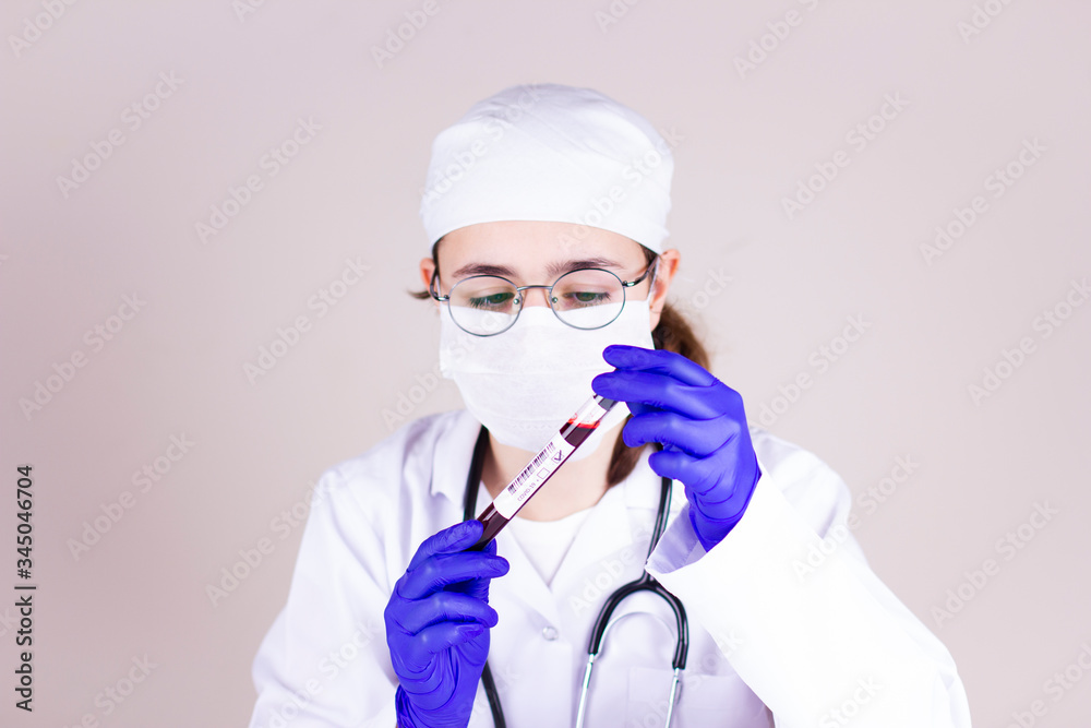 Nurse with respirator mask holding a tube with blood test result for coronavirus Nurse with respirator mask holding a tube with blood test result for coronavirus