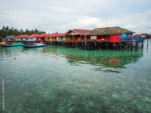 Colorful water cottages and boats at Derawan Island, North Kalimantan, Indonesia. Leisure and travel.