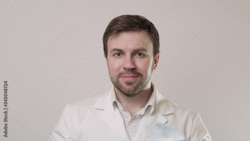 Medical worker taking off protective glasses, mask and throwing it away. Thumbs up. Smiling microbiologist at white background. Medium shot in 4K, UHD Medical worker taking off protective glasses, mask and throwing it away. Thumbs up. Smiling microbiologist at white background. Medium shot in 4K, UHD