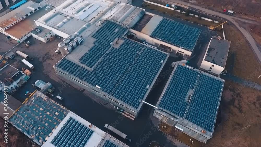Innovative solar farm on roofs. Blue solar panels on the top of industrial buildings of a plant. Renewable source of energy. Future technology concept. Aerial view. Innovative solar farm on roofs. Blue solar panels on the top of industrial buildings of a plant. Renewable source of energy. Future technology concept. Aerial view.