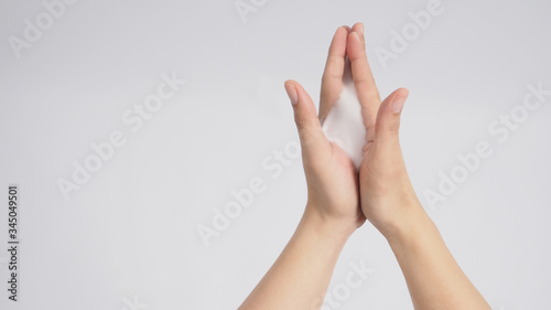 Male model is rubbing hand palms together with foaming hand soap on white background.