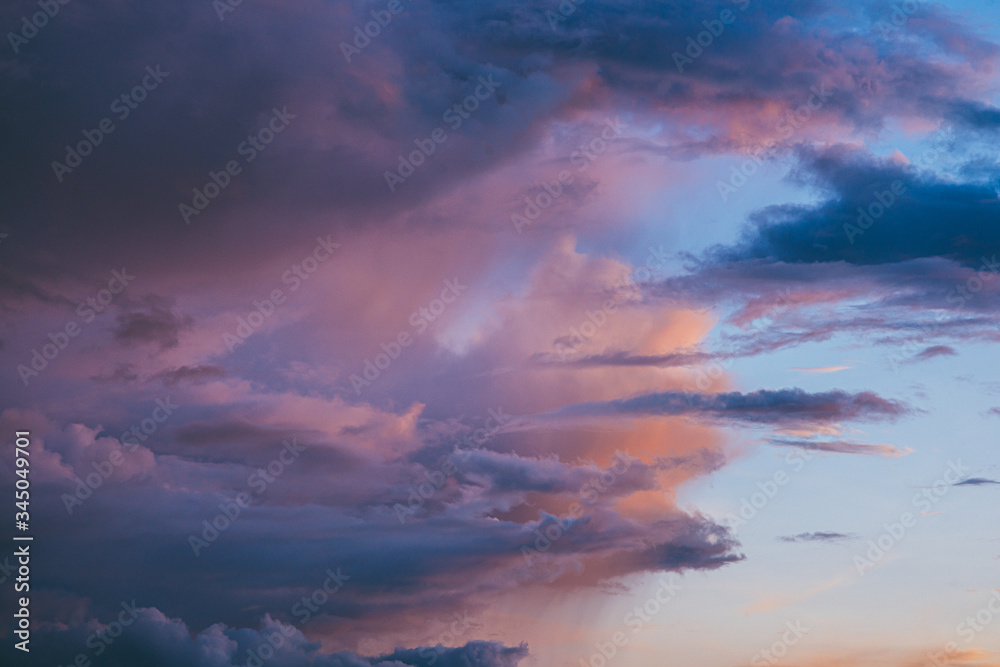 Evening sunset sky with bright rays of the sun and beautiful colorful clouds