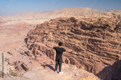 A man traveller standing and posing on top of mountain in Petra ruin and ancient city in Jordan, Arab
