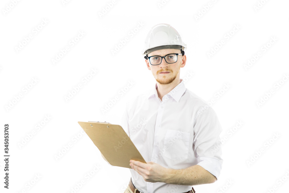 Handsome serious architect builder in hard hat holding clipboard with project documents and looking at camera isolated on white background. Successful man from heavy industry manufacturing