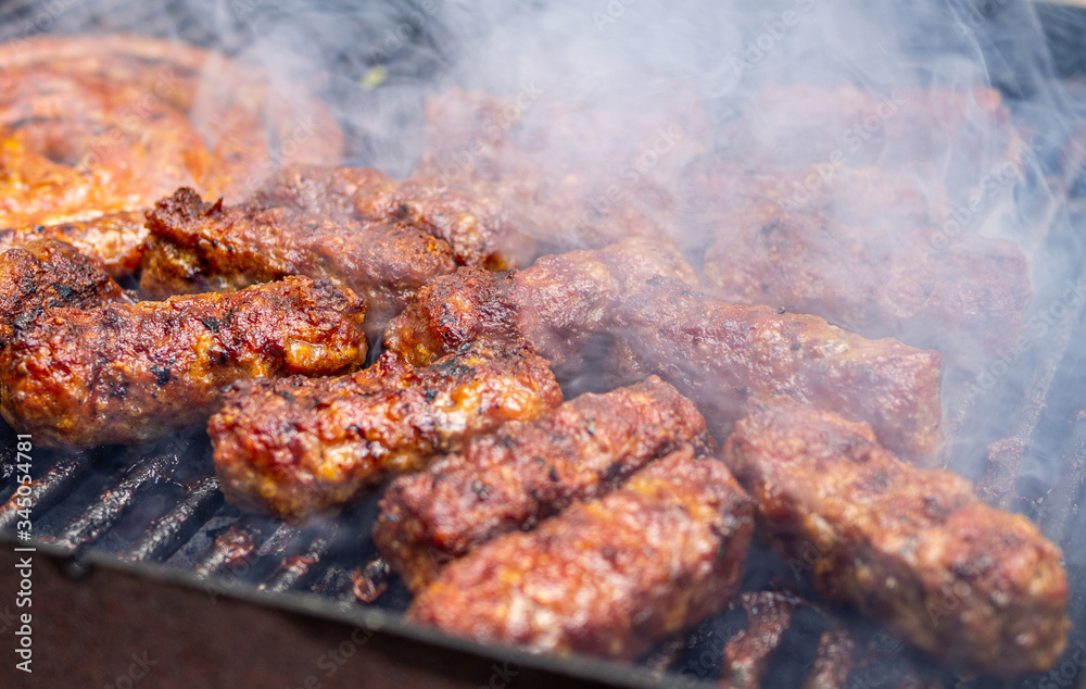 minced meat rolls or mici cooking on barbecue traditional romanain balkan ottoman dish 1st of may labor day celebration 