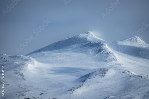 Winter landscape with dramatic snowy mountains.
