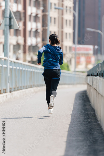 A young Asian Chinese woman is running