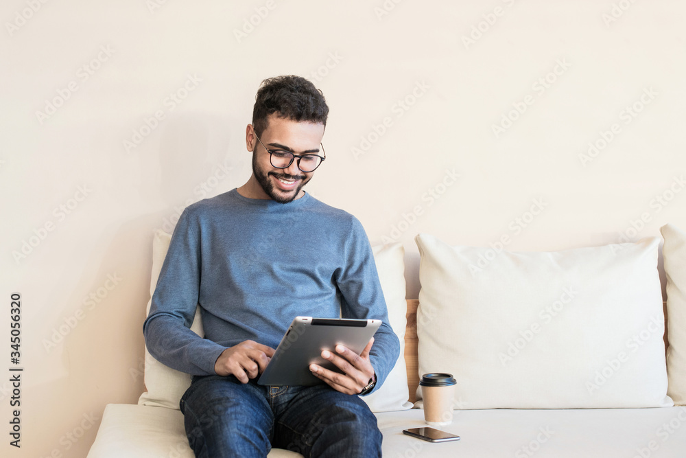 Young handsome man using digital tablet at home, Handsome student studying in his room, Home work or distance study, freelance, education online concept