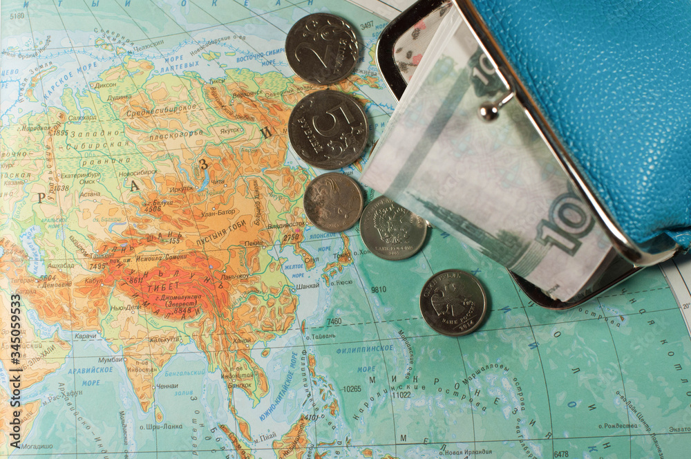 RUSSIAN money is on the geographical map of five thousand rubles in a blue purse. travel concept. RUSSIAN money is on the geographical map of five thousand rubles in a blue purse. travel concept.