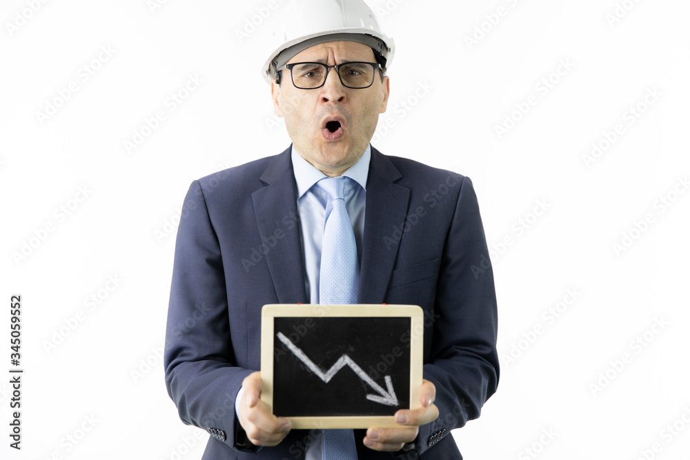 Shocked businessman in hard hat holds tablet with down arrow declining oil quotes. Oil refinery industry, stock drop, quotes reduction, collapse of market, production decline, petroleum engineering Shocked businessman in hard hat holds tablet with down arrow declining oil quotes. Oil refinery industry, stock drop, quotes reduction, collapse of market, production decline, petroleum engineering