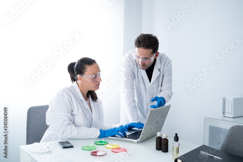 Young researchers or Scientists examining solution in petri dish at a laboratory. The researcher is analyzing the medicine related innovation. Biochemistry and Biotechnology concept