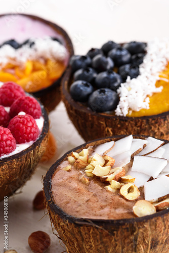Wallpaper Mural closeup four smoothie bowls with berries, fruit, nuts in coconut bowl on wooden table, vegetarian dessert Torontodigital.ca
