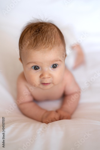 Cute baby girl crawling on bed