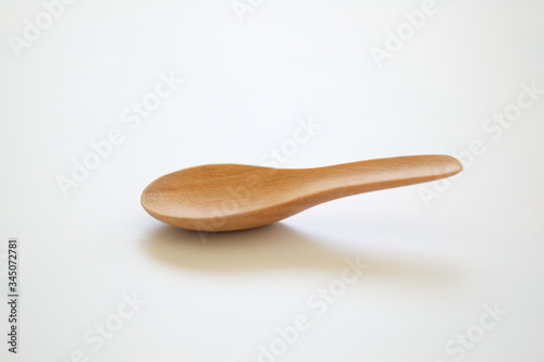 wooden chinese soup spoon  or asia spoon  is a type of spoon with a short  thick handle extending directly from a deep  flat bowl  isolated on white background. 