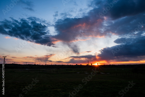 sunset with a beautiful sky on a golf course and a coal mine in the background , karvina