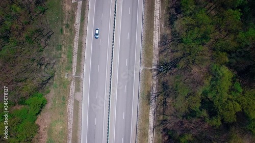 Aerial view above cars driving along empty countryside road on sunny day