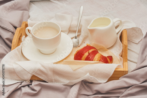 Breakfast in bed, coffee with cream, croissants in jam