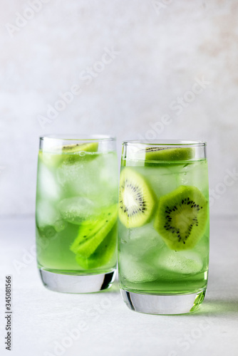 Glass of Refreshing Tropical Kiwi Lemonade With Ice on Light Gray Background Tasty Summer Beverage Healthy Detox Diet Drink Vertical