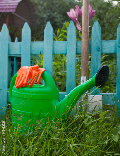 Watering can, protective gloves and metal spade.