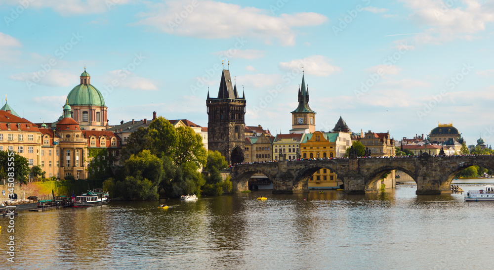Charles bridge, Old Town Bridge Tower and a green dome church beside Moldava river seen from Mala Strana (Lesser Town) in Prague, Czech Republic