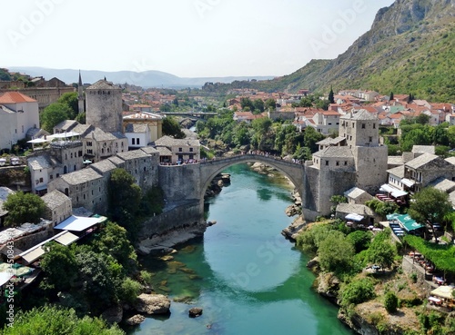 Imagen panorámica del icónico Puente Viejo de Mostar con sus torres a los lados sobre las aguas color turquesa del río Neretva