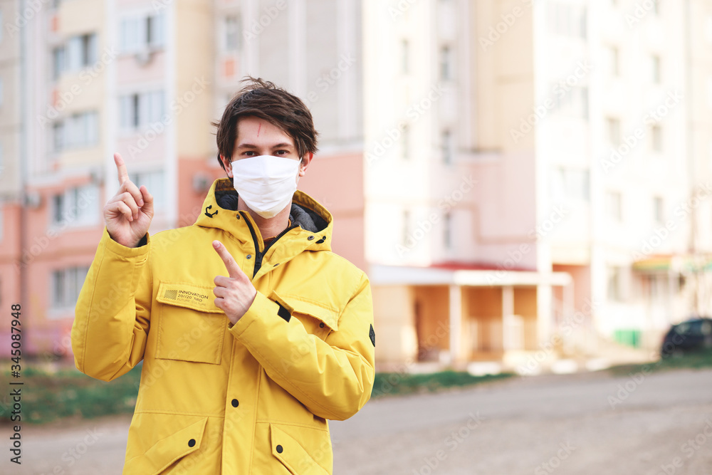 man standing outdoors wearing medical mask to protect others from virus spread